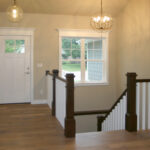 1502 Maple Hills Stairs + Foyer. Stained Newel Posts + Handrail with Painted White Square Wood Balusters. U-Shaped Stairs.
