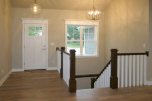 1502 Maple Hills Stairs + Foyer. Stained Newel Posts + Handrail with Painted White Square Wood Balusters. U-Shaped Stairs.