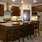 3435 Schubert Kitchen 3435 Schubert Kitchen. Granite Countertops. Stained Maple Flat Panel Custom Cabinets. Subway Tile Backsplash. Under-Cabinet Lighting. Luxury Vinyl Plank Floors. Stainless Chimney Range Hood.
