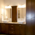 3435 Schubert Owners Bathroom Vanity. Stained Maple Flat Panel Custom Cabinets. Ceramic Tile Floors 45-Degree Pattern. Vessel Sinks. Granite Countertops.