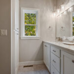 3492 Yorkshire Owner's Bathroom Vanity. Granite Countertops. Painted Cabinetry + Woodwork. Tile Floors. Wood Framed Mirror.
