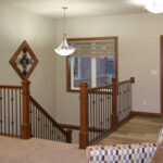 395 Whispering Creek Foyer + Stairs. Stained Maple LJ Smith Newel Posts with Black Iron Balusters. U-Shaped Stairs.