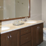 395 Whispering Creek Owners Bathroom Vanity. Stained Flat Panel Maple Cabinet. Granite Countertops. Wood Framed Mirror. Tile Flooring.