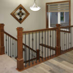 395 Whispering Creek Stairs. Stained Maple LJ Smith Newel Posts with Black Iron Balusters. U-Shaped Stairs.