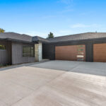 7736 Turnberry Exterior 7736 Turnberry Modern Exterior. Black Vertical Board & Batten Siding. Oak woodgrain Overhead Garage Doors,