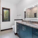 7736 Turnberry Main Bath Vanity. Tiled Floors. Modern Slab Front Cabinets. Lighted Mirrors. Quartz Countertops.