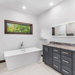 7736 Turnberry Owners Bathroom Vanity + Freestanding Tub. Ceramic Tile Floors. Slab Front Modern Cabinets. Quartz Countertops.