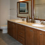 1726 Symphony Heights Main Bathroom. Quartz Countertops. Ceramic Tile Floors. Stained Maple Vanity. Wood Framed Mirrors.