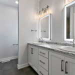 4976 Plum Bottom Rd Owners Bathroom Vanity. White Painted Cabinets. Lighted Mirrors. Vinyl Tile Floors.