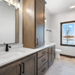 311 S Splake Owners Bathroom. Stone Countertops. Custom Stained Maple Cabinets. Black Framed Mirrors.