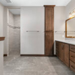 3597 E Hank Owners Bathroom. Stained Maple Cabinets. Slip-In Linen. Wood-Framed Mirror. Zero Entry Barrier-Free Tiled Shower. Ceramic Tile Floors