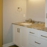 2411 Pristine Main Bathroom. Granite countertops with white painted flat panel cabinets.