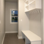 2411 Pristine Mud Room. White Painted Bench, Coat Hooks, and Open Cubbies Above.