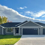 526 Rosemary Exterior. Black windows, black entry door, black overhead garage doors, white soffit/fascia, white exterior trim boards, Mitten "Yukon Gray" vinyl siding, CertainTeed Landmark "Moire Black" shingles.