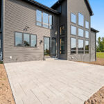 10510 Sugar Creek Exterior. Black siding with black windows. Stamped Concrete Patio.
