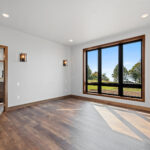 10510 Sugar Creek Owners Bedroom. Vinyl plank floors, wall sconces, black interior windows, vinyl plank flooring.
