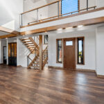 10510 Sugar Creek Foyer + Open Riser Stairs. Maple Glu-Lam, Black Cable Rail, Ceiling Beams.