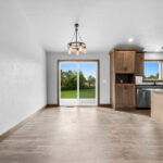 4749 Whitefish Bay Dining. Avery Grove Weathered Barn Oak Vinyl Plank Floors. Stained Maple Flat Panel Custom Cabinetry. Black Pearl Granite Countertops. SW7029 Agreeable Gray.