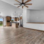 4749 Whitefish Bay Main Living Areas. Avery Grove Weathered Barn Oak Vinyl Plank Floors. Stained Maple Flat Panel Custom Cabinetry. Black Pearl Granite Countertops. SW7029 Agreeable Gray. Chimney Range Hood. Cathedral Ceiling.