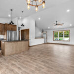 4749 Whitefish Bay Main Living Areas. Avery Grove Weathered Barn Oak Vinyl Plank Floors. Stained Maple Flat Panel Custom Cabinetry. Black Pearl Granite Countertops. SW7029 Agreeable Gray. Chimney Range Hood. Cathedral Ceiling.