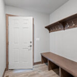 237 Park St Mud Room. Stained Maple Bench with Coat Hooks & Shelf. Luxury Vinyl Plank Floors.
