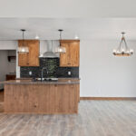 7120 Morrison Rd Kitchen + Dining. Stained Knotty Alder Cabinetry. Look Nero "Jet Black" Glossy Tiled Backsplash. Wilsonart "Spicewood Springs" laminate countertops.