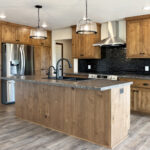 7120 Morrison Rd Kitchen. Stained Knotty Alder Cabinetry. Look Nero "Jet Black" Glossy Tiled Backsplash. Wilsonart "Spicewood Springs" laminate countertops.