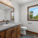 7120 Morrison Rd Main Bathroom. Stained Maple Cabinetry and Mirror Frame. Adura Flex "Carbon" Vinyl Tile Flooring.