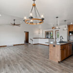 7120 Morrison Rd Main Living Areas. Avery Grove "Weathered Barn Oak" Vinyl Plank Floors. Stained Knotty Alder Cabinets.