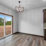 4673 Mill Rd Dining. Lone Star Spirit "Ballroom Rodeo" 9" Wide Vinyl Plank Flooring. Stained Maple Cabinetry + Woodwork.