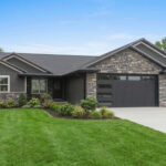 4673 Mill Rd Exterior. CertainTeed Landmark "Moire Black" Shingles. Gentek "Iron Ore" Siding. ProVia "Terra Cut Flintridge" Thin Stone Veneer with 97A Super Black Colored Mortar. Overhead Garage Doors with Flush Panels and Horizontal and Vertically Stacked Window Glass Inserts. Black Fascia with White Drip Edge.