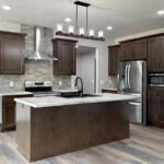 4673 Mill Rd Main Kitchen. Formica "Sea Pearl" Laminate Countertops. Grand Canyon "Sagebrush" Tiled Backsplash. Lone Star Spirit "Ballroom Rodeo" 9" Wide Vinyl Plank Flooring. Cathedral Ceiling. Stained Maple Cabinetry + Woodwork.