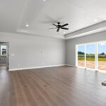 E1999 Hillside Great Room. Kentmore Lodge "Natural Canvas Oak" Vinyl Plank Flooring. Stairs with Half Wall and Wood Cap. Tray Ceiling.