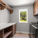 E1999 Hillside Laundry. Kentmore Lodge "Natural Canvas Oak" Vinyl Plank Flooring. Stained Maple Cabinets with Hanging Pole & Shelf.